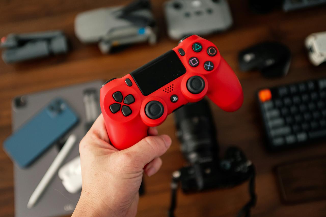 a person holding a red video game controller